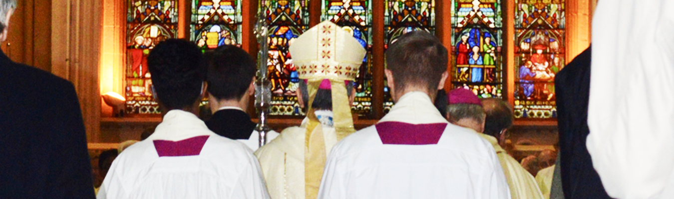 Bishop John Arnold and servers gather in front of the west window